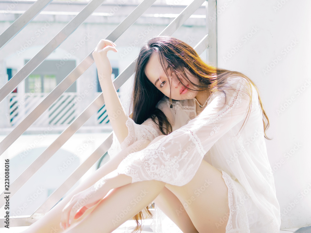 Beautiful Chinese girl sit on floor in sunny days, portrait of romantic young female looking at camera with sexy expression. Stock Photo | Adobe Stock